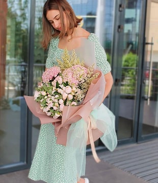 Дівчина тримае букет квітів