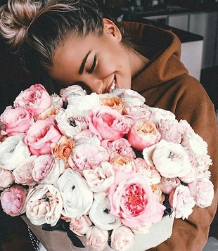 Дівчина тримае букет квітів