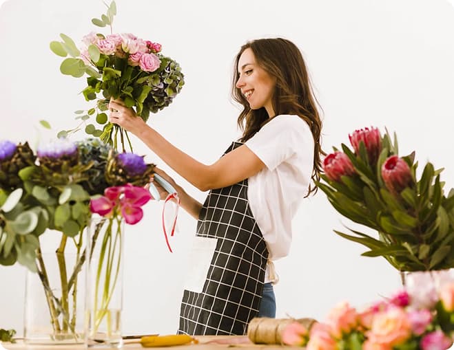 Флорист збирає букет з білих і рожевих роз
